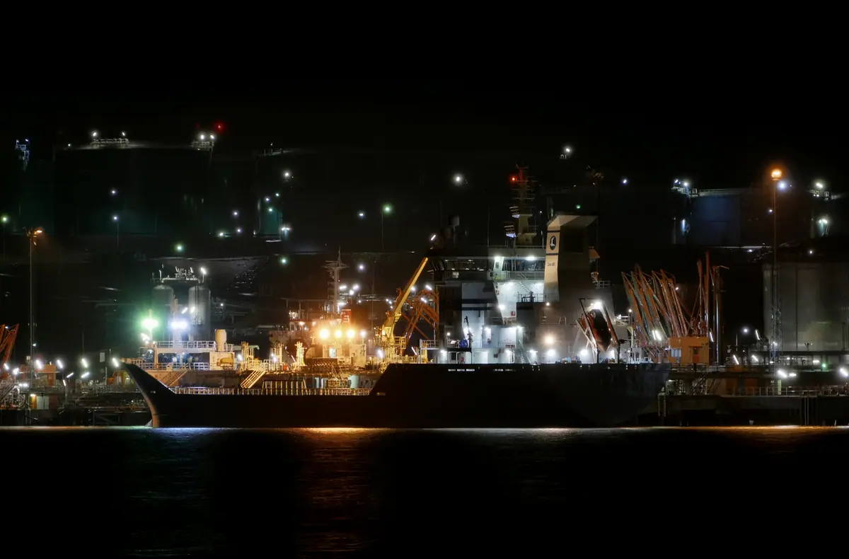 A products tanker berthed at an illuminated petroleum terminal at night